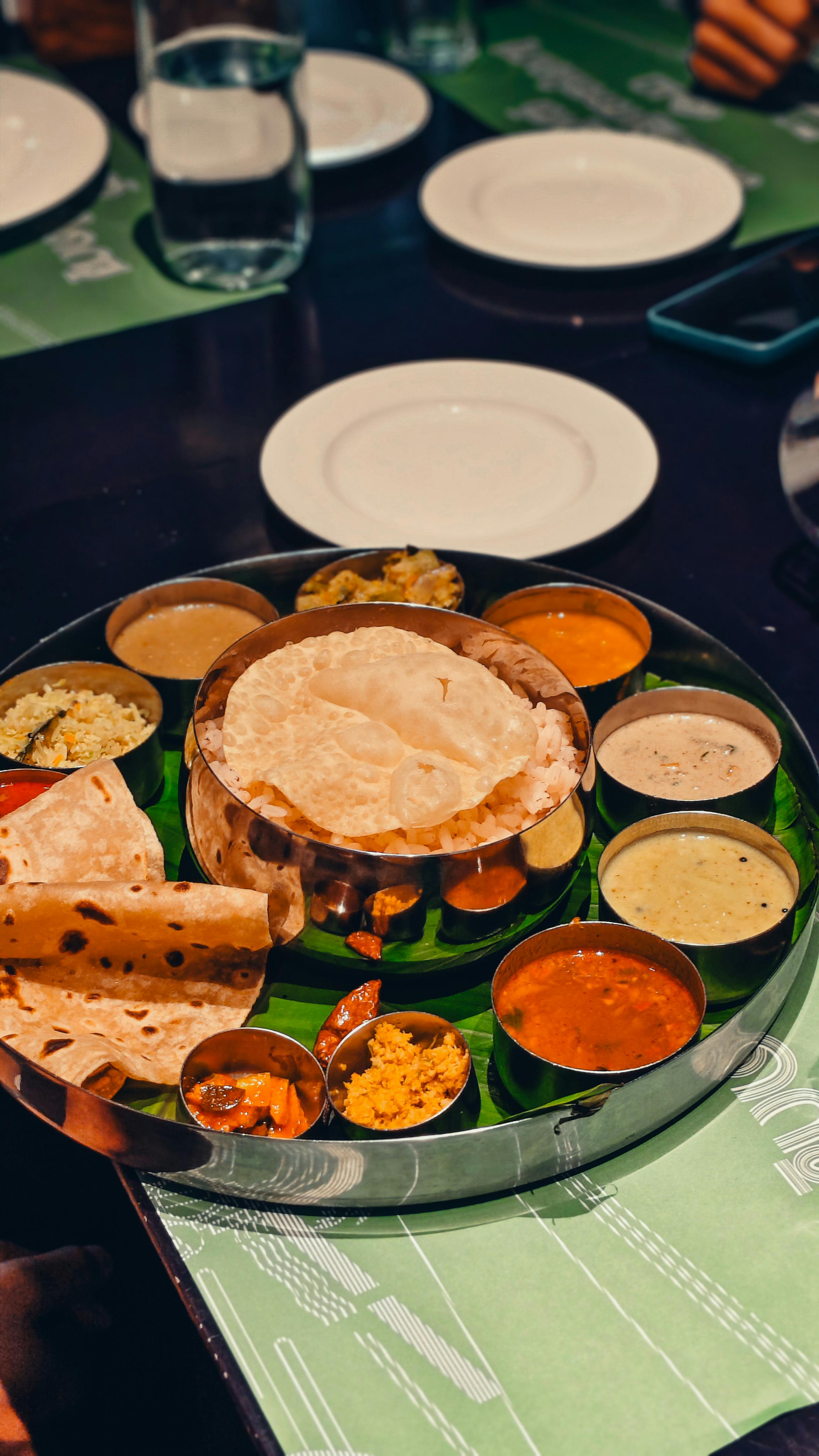 Close-up of Indian curry bowl with naan bread and herbs
